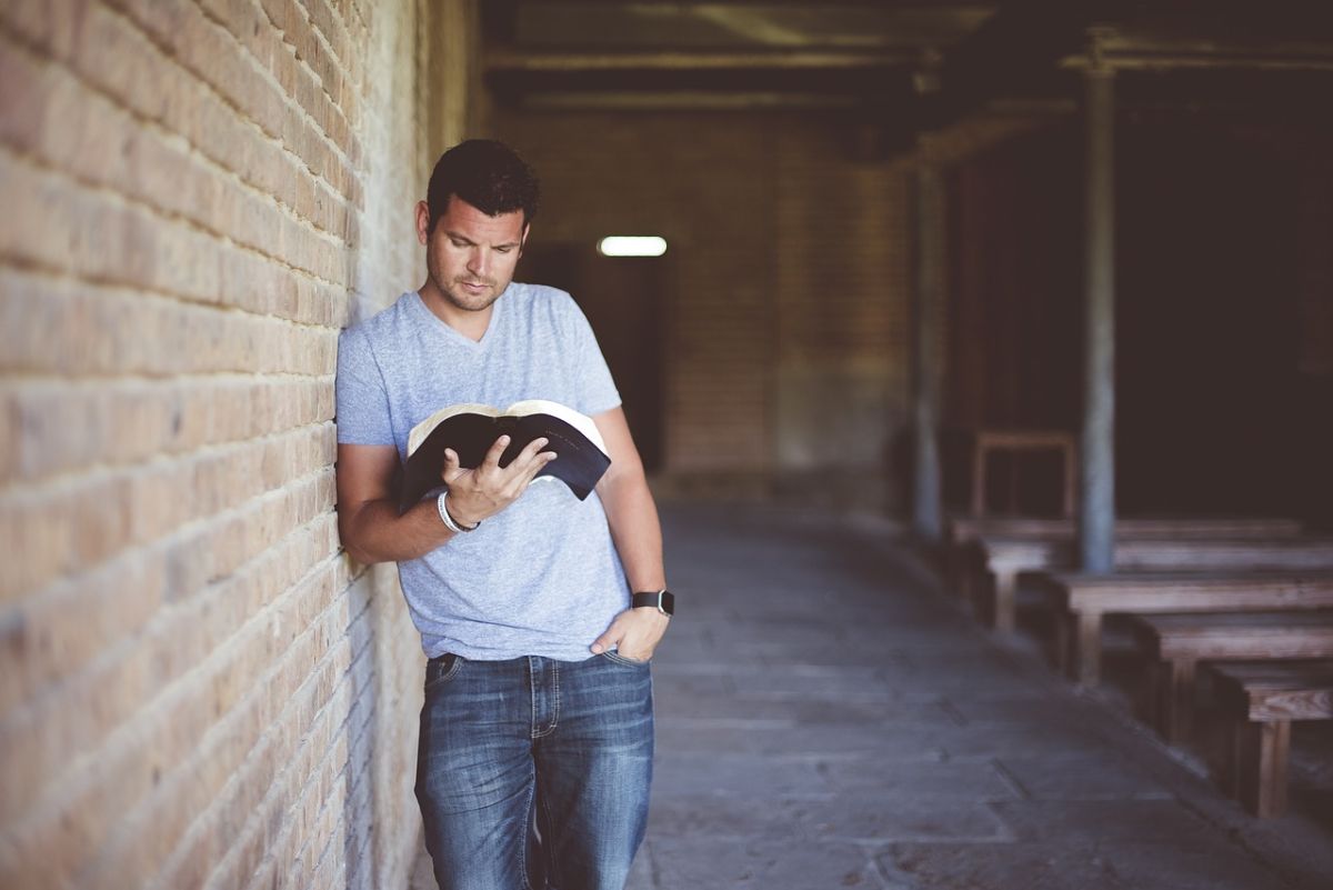 hombre de pie leyendo